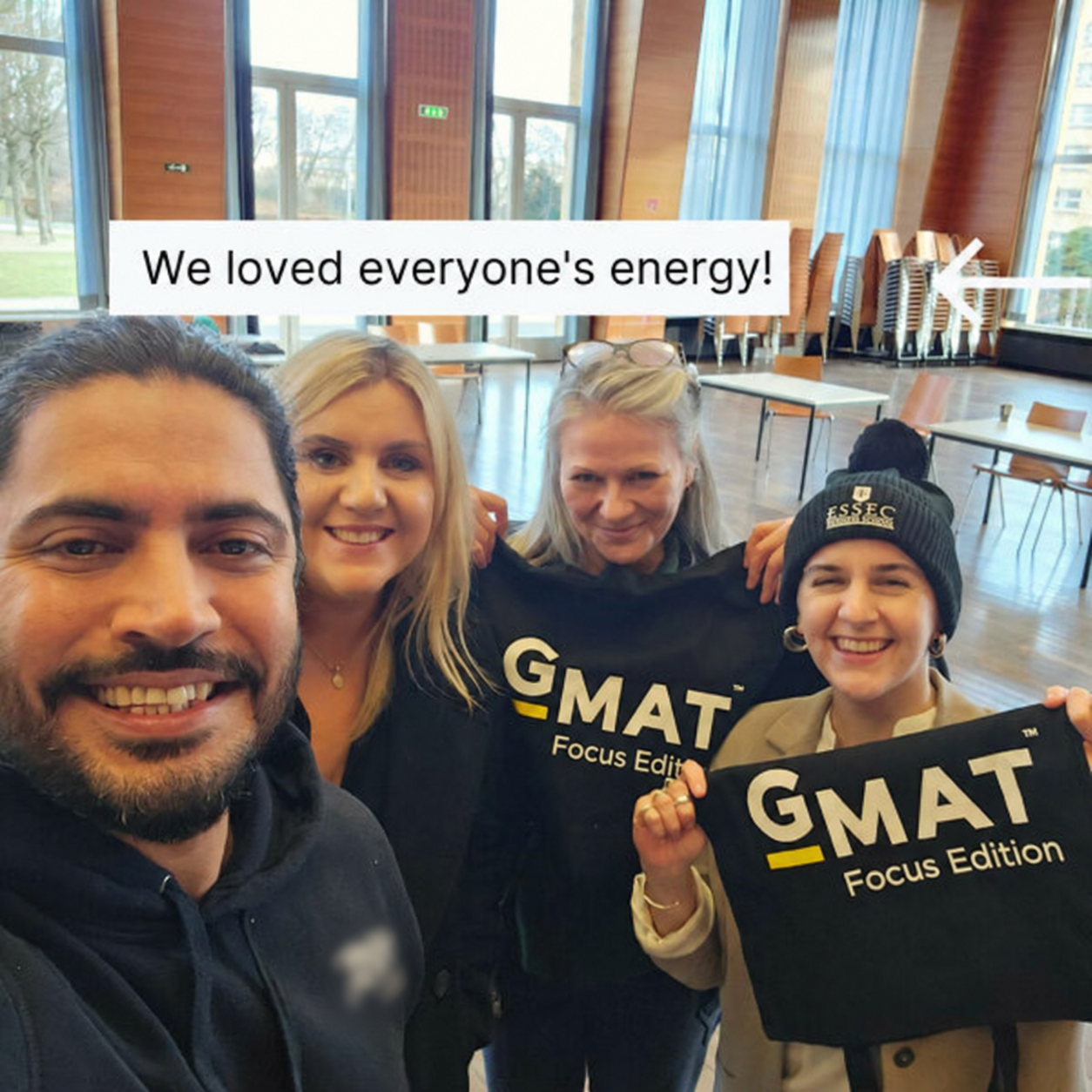 Candidates and coaches at an ITEROS event holding GMAT Focus Edition banners